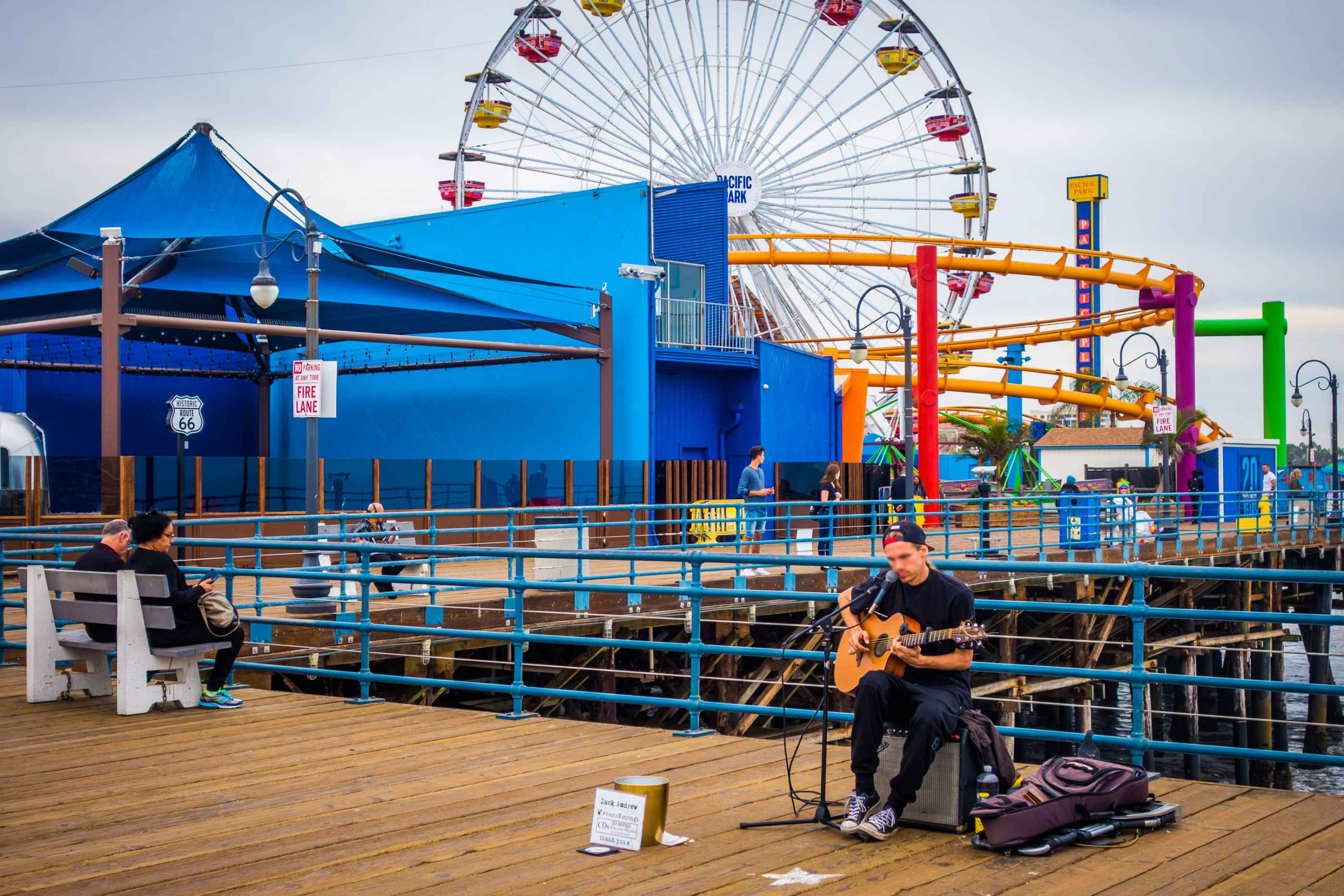 Un artiste joue de la guitare sur le ponton du parc d'attraction de Venice Beach